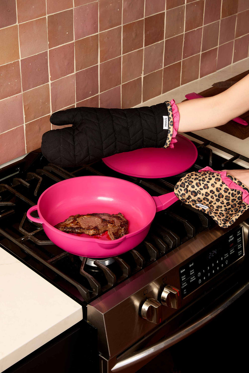 Lynnee Oven Mitt and Pot Holder Set, Leopard, Hot Pink and Black with Girly Ruffles and hanging loop cooking yummy steak in 11" Hot Pink Frying Pan in the kitchen