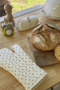 For Love & Lemons x Lynnee Baby Bows Ceramic Butter Dish and Lady Dot Polka Dot Oven Mitt on cutting board with bread