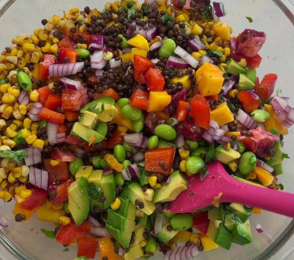 A vibrant bowl of Nectar Caviar with mango and edamame, featured next to a Lynnee Pink Pan used for charring miso corn.