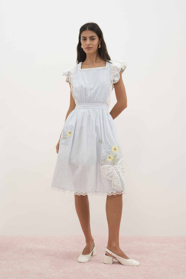 For Love & Lemons x Lynnee Collab Model wearing Bluebell Gingham Apron with flowers and bows, front view