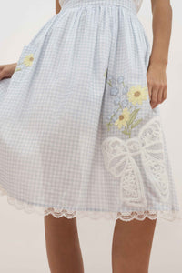 For Love & Lemons x Lynnee Collab Model wearing Bluebell Gingham Apron with flowers and bows, lace trim, detail shot