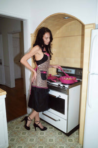 Sydney Carlson wearing Lynnee Kitchen Apron Leopard, Hot Pink and Black with Girly Lace and Ruffles, using 11" Hot Pink Frying Pan cooking Pasta, with Spatula 